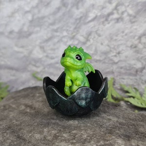 Newborn green dragon in egg. Little cute miniature of dragon!