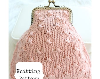 May include: A pink knitted coin purse with a metal clasp. The purse has a delicate stitch pattern and is sitting on a white fluffy surface. The text "Knitting Pattern" is visible in the lower left corner of the image.