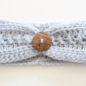 May include: A light blue crocheted headband with a wooden button in the center.
