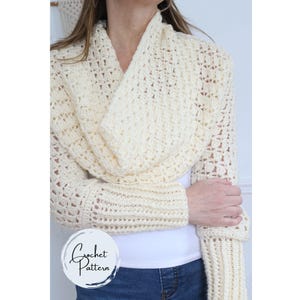 Puede incluir: Bolero de crochet color crema con mangas largas. El diseño de tejido abierto presenta un patrón texturizado. Las mangas tienen un puño acanalado. El bolero se usa sobre una camiseta blanca. La imagen incluye un logotipo que dice "Crochet Pattern".
