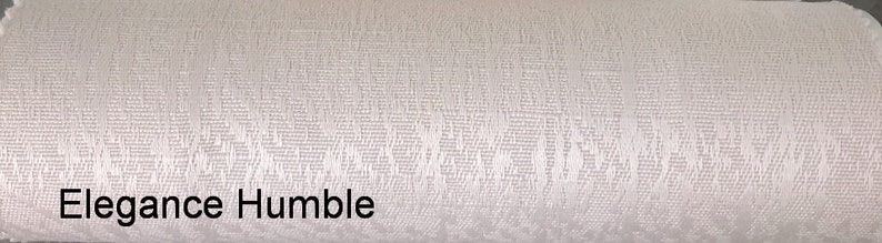 May include: White fabric with a subtle textured pattern. The fabric has a soft, smooth feel and a slightly iridescent sheen. The text "Elegance Humble" is printed in black at the bottom of the image.