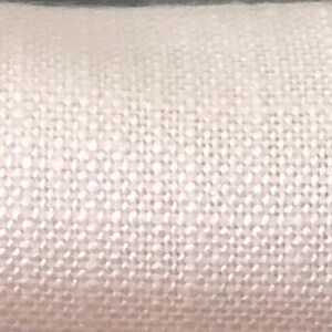 May include: Close-up of a white fabric swatch with the text "Galaxy Blossom" printed on it.