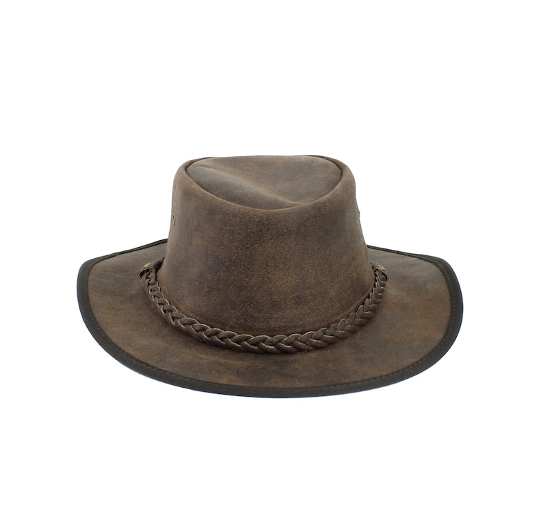 Pu&ograve; includere: Un cappello da cowboy in pelle marrone con una fascia in pelle intrecciata.