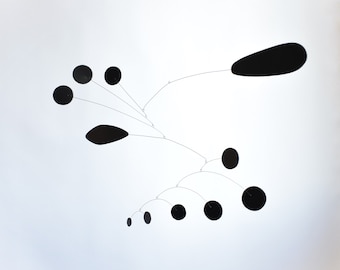 Peut inclure: Une sculpture mobile noire avec des éléments circulaires et en forme de larme suspendus à un point central.