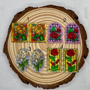 May include: Assortment of six stained glass style flower embellishments.  The embellishments feature yellow roses, red roses, and white calla lilies.  The embellishments are numbered 1 through 6.