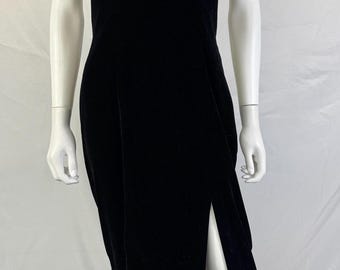 May include: A black velvet sleeveless dress featuring a high halter neckline adorned with a decorative collar of gold, silver, and clear beads and sequins. The floor-length garment includes a high side slit along the left leg, creating a sleek silhouette.