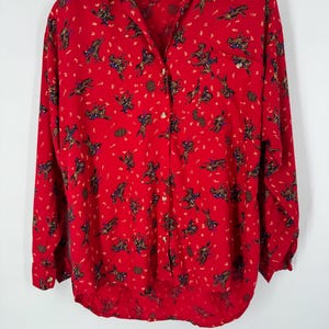 May include: A white ceramic mug with a black handle and the text "But First, Coffee" in a bold, black font. The mug is set against a blurred background, suggesting a cozy setting. The mug appears to be approximately 4 inches tall.