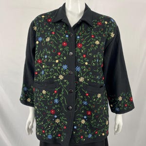 May include: A black button-up jacket with a floral embroidery design. The embroidery features a variety of colors, including red, blue, green, and yellow.