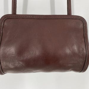 May include: A dark brown leather shoulder bag with a flap closure and a single strap.