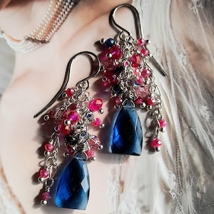 May include: A pair of dangle earrings with blue gemstone drops and pink and silver beads.