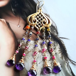 May include: Gold dangle earrings with a filigree design and multiple strands of colourful beads. The strands are topped with amethyst gemstones.