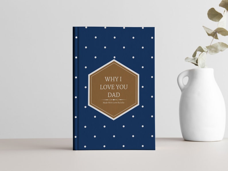 Peut inclure: Un livre bleu &agrave; pois blancs avec un hexagone brun sur lequel est inscrit "WHY I LOVE YOU DAD" et "Made With Love by Julia".
