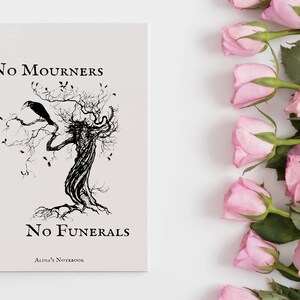 K&ouml;nnte beinhalten: Ein spiralgebundenes Notizbuch mit einer Schwarzwei&szlig;illustration eines Baumes mit einem Raben, der auf einem Ast sitzt. Der Text "No Mourners No Funerals Alina's Notebook" ist auf dem Cover gedruckt.
