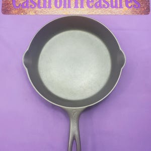 May include: A cast iron skillet with a black handle. The skillet is 7 inches in diameter and has a smooth, gray surface.