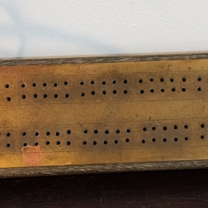 Planche à cribbage vintage en laiton et bois.