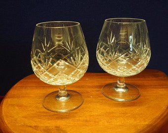 Puede incluir: Dos copas de brandy de cristal transparente con un patrón de diamante sobre una superficie de madera.