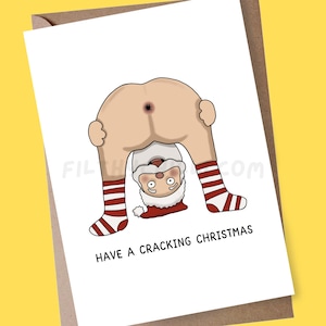 May include: A funny Christmas card with a cartoon Santa Claus bent over, showing his bottom. Santa's face and legs are visible, with red and white striped socks. The text "HAVE A CRACKING CHRISTMAS" is printed below the image.