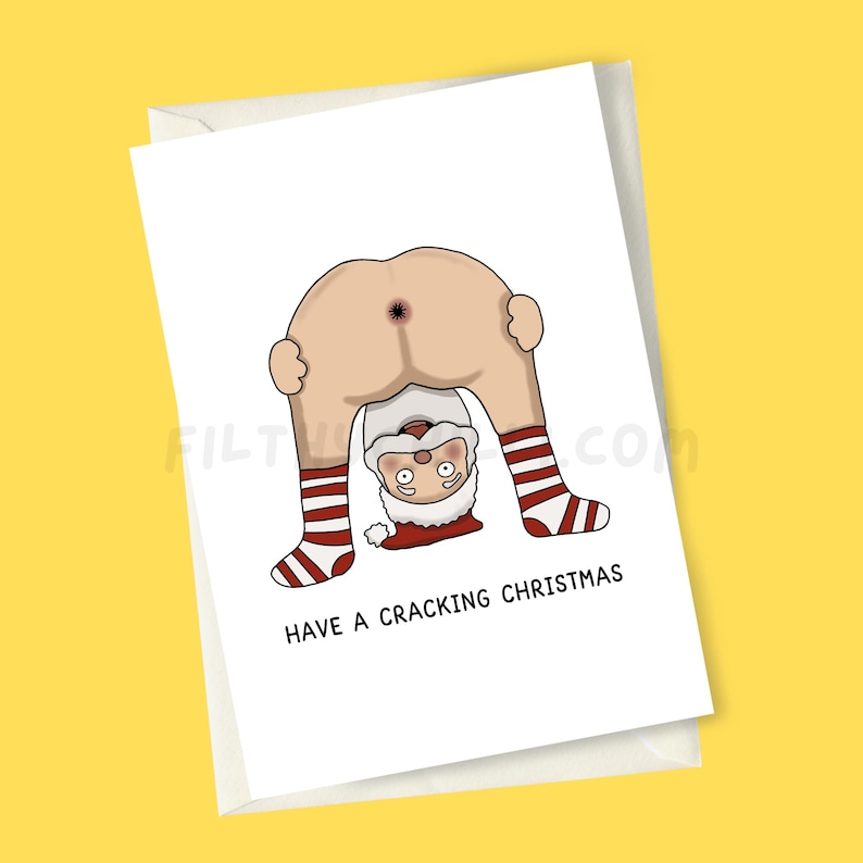 May include: A white Christmas card featuring a cartoon Santa Claus bent over, with his backside on display. Santa's legs are seen, wearing red and white striped socks. The card reads "HAVE A CRACKING CHRISTMAS" in black text.