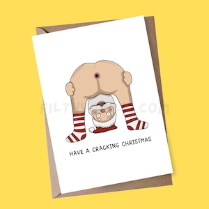 May include: A white Christmas card featuring a cartoon Santa Claus bent over, showing his backside. Santa is wearing red and white striped socks. The card reads "HAVE A CRACKING CHRISTMAS" in black text.