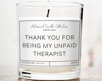 Op de afbeelding: Een glazen kaars pot met een wit label waarop staat "Antisocial Candle Collection" en "Bedankt dat je mijn onbetaalde therapeut bent". Het label bevat ook "Notes of: Gratitude" en "25HR".
