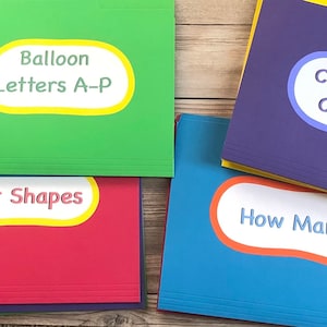 May include: Four colorful file folders with labels for educational activities. The labels read "Balloon Letters A-P", "Color Shapes", "Caterpillar Counting", and "How Many?" The folders are green, red, purple, and blue.