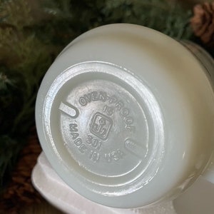 May include: White ceramic bowl with a white rim and a circular label on the bottom that reads "Oven-Proof 301 Made in USA".