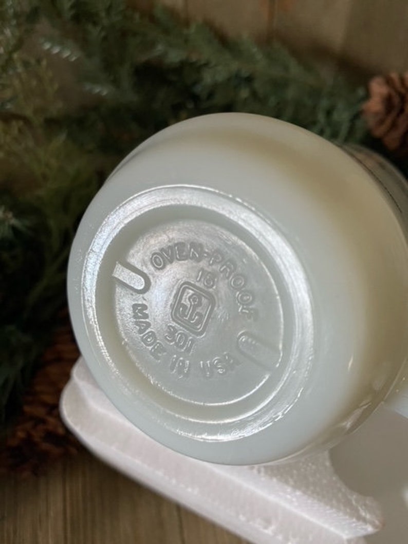 May include: White ceramic bowl with a white rim and a circular label on the bottom that reads "Oven-Proof 301 Made in USA".