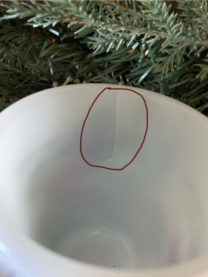 May include: White ceramic mug with a red circle drawn on the inside of the mug.