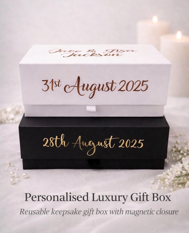 May include: A white rectangular gift box with rose gold text reading "Jave & Lisa Jackson" and "31st August 2025" stacked on a black rectangular gift box with gold text reading "28th August 2025". Both boxes feature a magnetic closure.