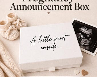 May include: A white rectangular gift box with the text A little secret inside printed on the lid. The box is accompanied by a pair of beige knit baby booties, a black and white ultrasound scan, and two small wooden heart-shaped cutouts.
