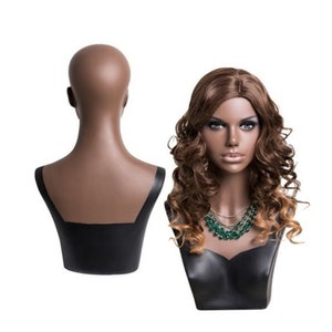 May include: A brown mannequin bust with a black base, featuring a long, wavy brown wig with blonde highlights. The bust is designed for displaying necklaces and other jewelry.
