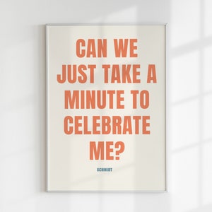 Könnte beinhalten: Ein gerahmter Druck mit dem Text "Can we just take a minute to celebrate me?" in Orange auf cremefarbenem Hintergrund. Der Text "Schmidt" steht in Blau am unteren Rand des Drucks.