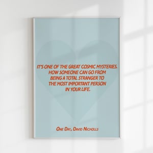 Pode incluir: Um cartaz azul claro com uma forma de coração no centro. O cartaz apresenta uma citação em texto laranja: "É um dos grandes mistérios cósmicos. Como alguém pode passar de ser um completo estranho à pessoa mais importante da sua vida." A citação é atribuída a "One Day, David Nicholls".