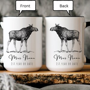 May include: White ceramic mug with a black handle and rim, featuring a detailed black and white illustration of a moose. The mug has the text "Mrs. Name" and "EST. YEAR OR DATE" in a script font.