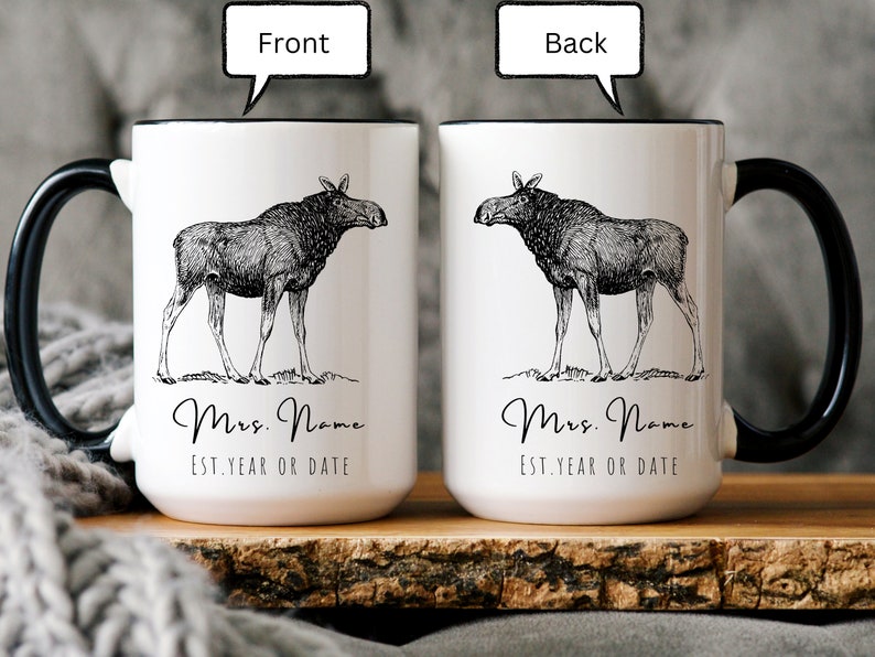 May include: White ceramic mug with a black handle and rim, featuring a detailed black and white illustration of a moose. The mug has the text "Mrs. Name" and "EST. YEAR OR DATE" in a script font.