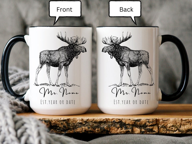 May include: White ceramic mug with a black handle and rim, featuring a detailed black and white illustration of a moose. The mug has the text "Mr. Name" and "Est. Year or Date" in a script font. The image shows the front and back of the mug.