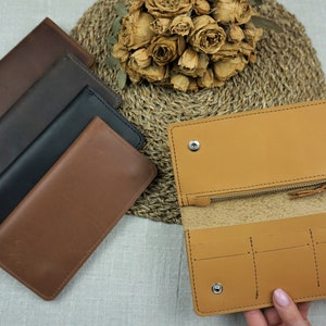 Puede incluir: Cuatro carteras de cuero en diferentes colores, incluyendo marr&oacute;n, negro y beige. Las carteras est&aacute;n dispuestas en una pila, con la beige en la parte superior. Las carteras est&aacute;n todas cerradas, y la beige est&aacute; abierta para mostrar el interior.