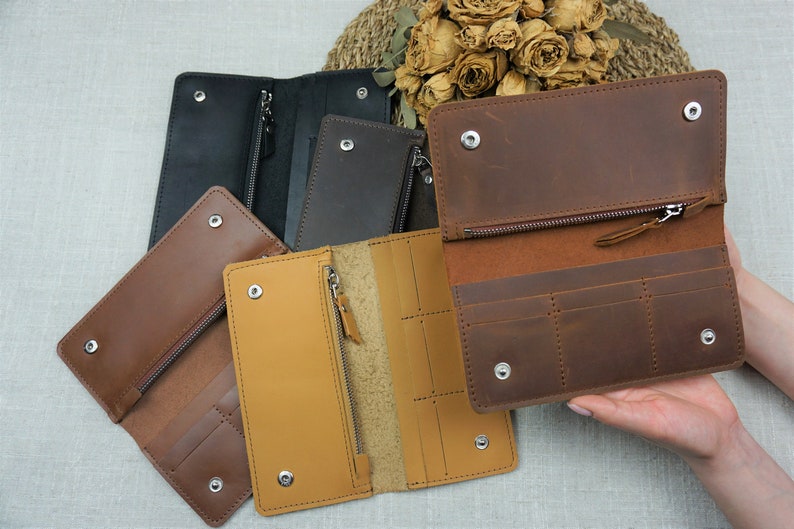 Puede incluir: Cuatro carteras de cuero en diferentes colores, incluyendo marr&oacute;n, negro y amarillo. Las carteras tienen m&uacute;ltiples ranuras para tarjetas y un compartimento con cremallera.