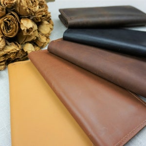 Puede incluir: Cinco carteras de cuero en diferentes colores, incluyendo marr&oacute;n, negro, beige y un marr&oacute;n m&aacute;s claro. Las carteras est&aacute;n apiladas una encima de la otra, con la cartera marr&oacute;n en la parte superior.