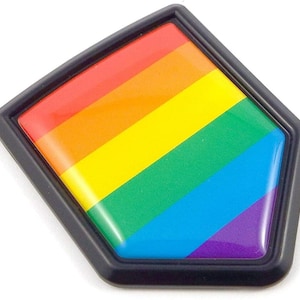 May include: A rainbow-colored badge with a black border. The badge features a vibrant design of horizontal stripes in the colors of the rainbow: red, orange, yellow, green, blue, and purple. The badge has a glossy finish.