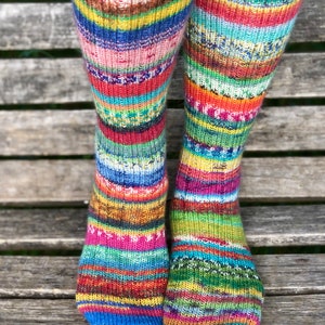 May include: A pair of colourful striped socks featuring a range of colours, including red, blue, green, yellow, and orange. The socks are made from a soft, comfortable material and are ideal for everyday wear.