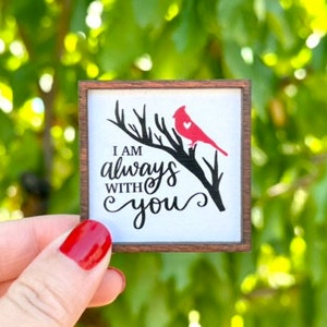May include: A wooden sign with a red cardinal perched on a branch. The sign reads "I am always with you" in black cursive lettering.