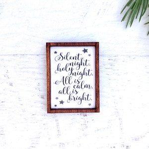 Peut inclure: Petit panneau rectangulaire encadr&eacute; de bois avec l'inscription "Silent night. holy night. All is calm. all is bright." en &eacute;criture &eacute;l&eacute;gante. Le panneau a un fond blanc avec des &eacute;toiles grises.