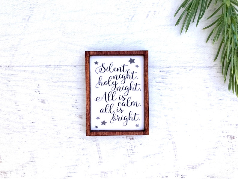 Peut inclure: Petit panneau rectangulaire encadr&eacute; de bois avec l'inscription "Silent night. holy night. All is calm. all is bright." en &eacute;criture &eacute;l&eacute;gante. Le panneau a un fond blanc avec des &eacute;toiles grises.