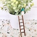 https://www.etsy.com/listing/1218452803/miniature-wooden-ladder-o-farmhouse?ls=a&ga_order=most_relevant&ga_search_type=all&ga_view_type=gallery&ga_search_query=small+decorative+ladders&ref=sc_gallery-1-4&sts=1&loc=1&local_signal_search=1&plkey=Eug3JEMdtvXCNw-SKBLH5BRJdE6a%3ALT804e916c1b33abaaee6141b56ee9ad3f1a297aa6
