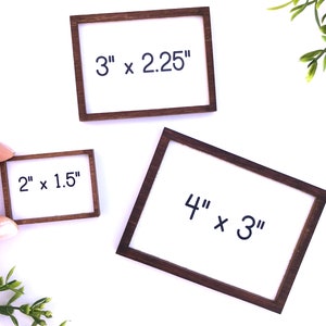 May include: Three small wooden frames with white inserts. The frames are labeled with their dimensions: 3" x 2.25", 2" x 1.5", and 4" x 3". The frames have a dark brown finish.