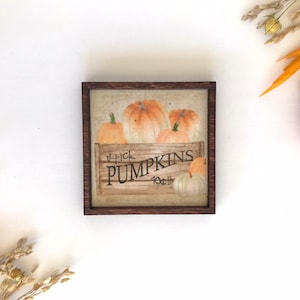May include: A framed painting of a wooden crate filled with orange pumpkins. The crate has a sign that reads "U-Pick Pumpkins 10¢/lb".