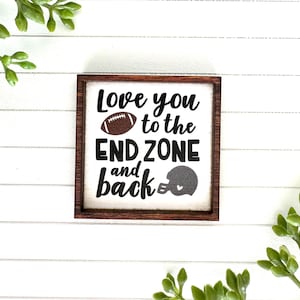 May include: A wooden sign with the text "Love you to the end zone and back" with a football and a football helmet graphic.