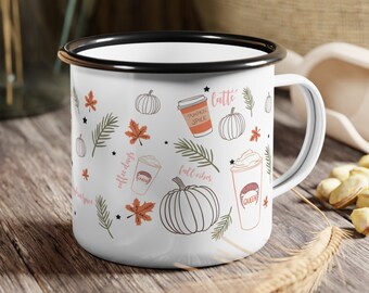 Puede incluir: Taza de esmalte blanco con borde y asa negros. La taza presenta un diseño de otoño con calabazas, hojas y tazas de café. El texto en la taza dice "latte", "pumpkin spice", "fall vibes" y "coffee days".
