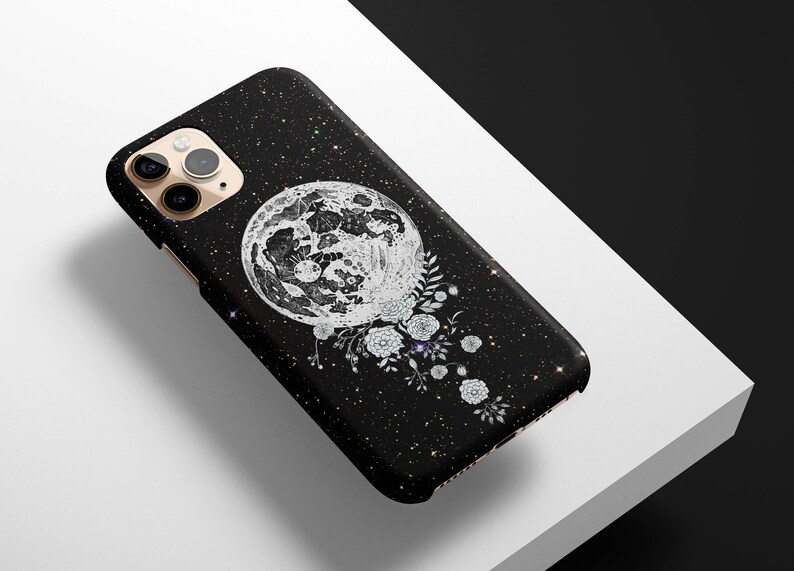May include: Black phone case with a white moon and floral design on a black glitter background.